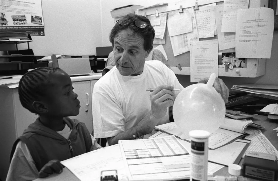 Dr Eric Goemaere gives a blown up glove to a young HIV patient.